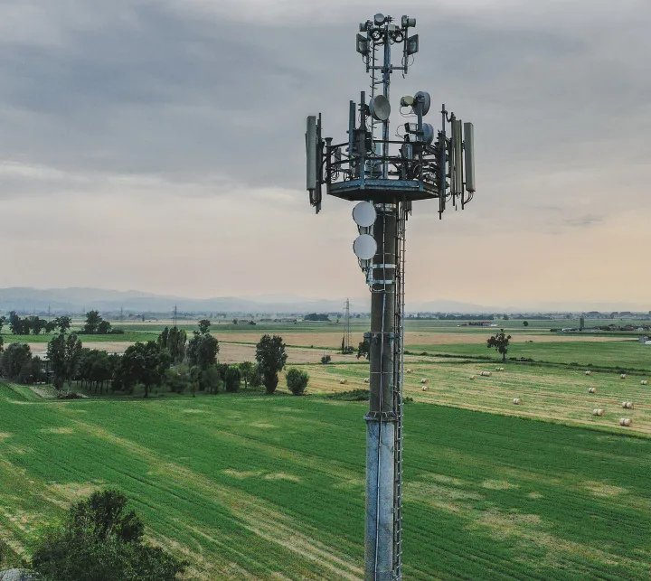 Telecommunication tower standing in cultivated agricultural field